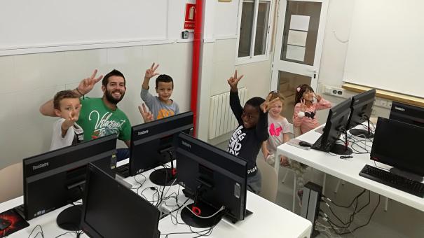 Grup d'infants del Casal Infantil fent classe de programació