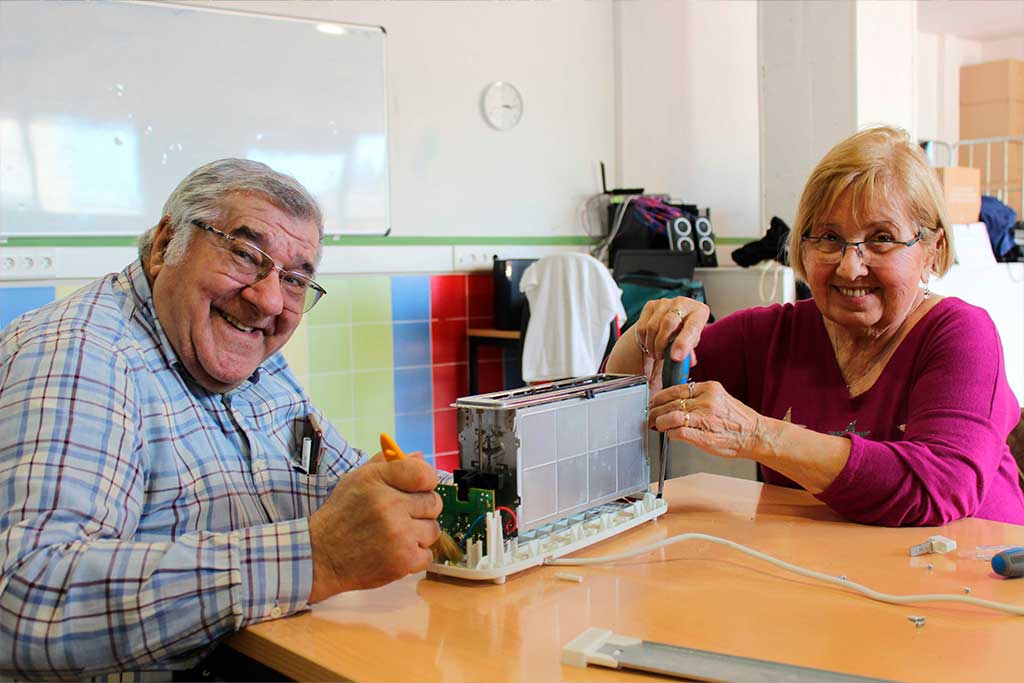 Participants del taller re-connecta reparen una torradora.